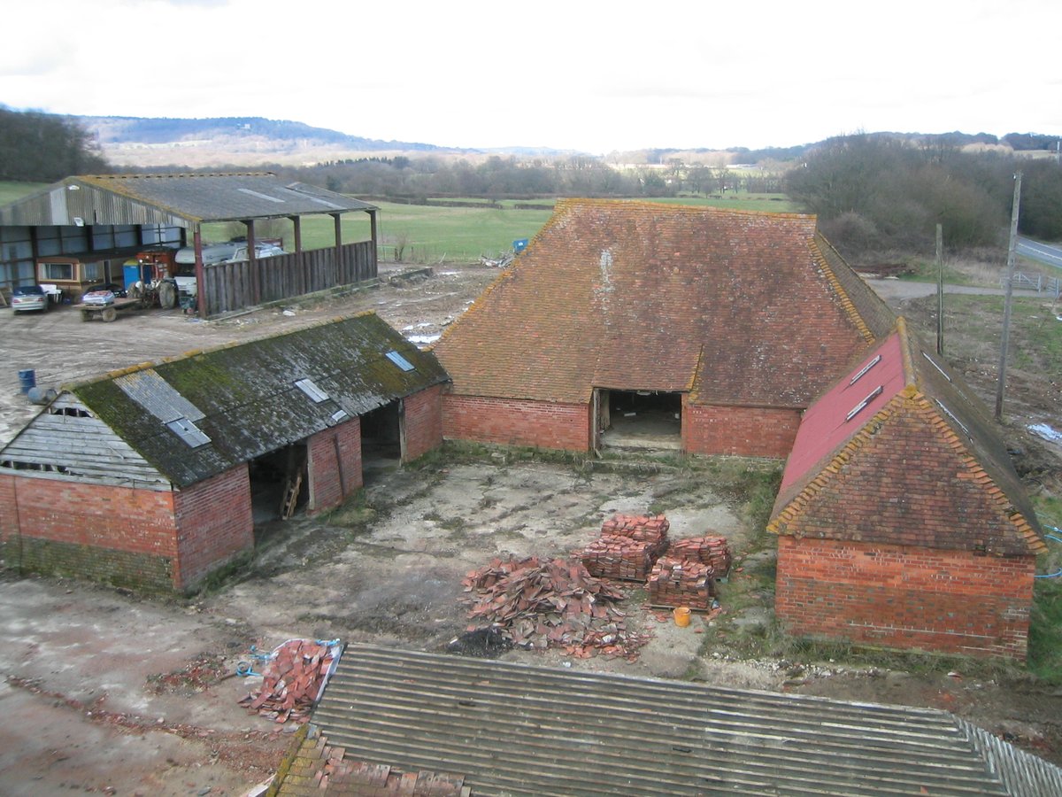 Original brick barn courtyard before restoration — heritage barn site, West Sussex