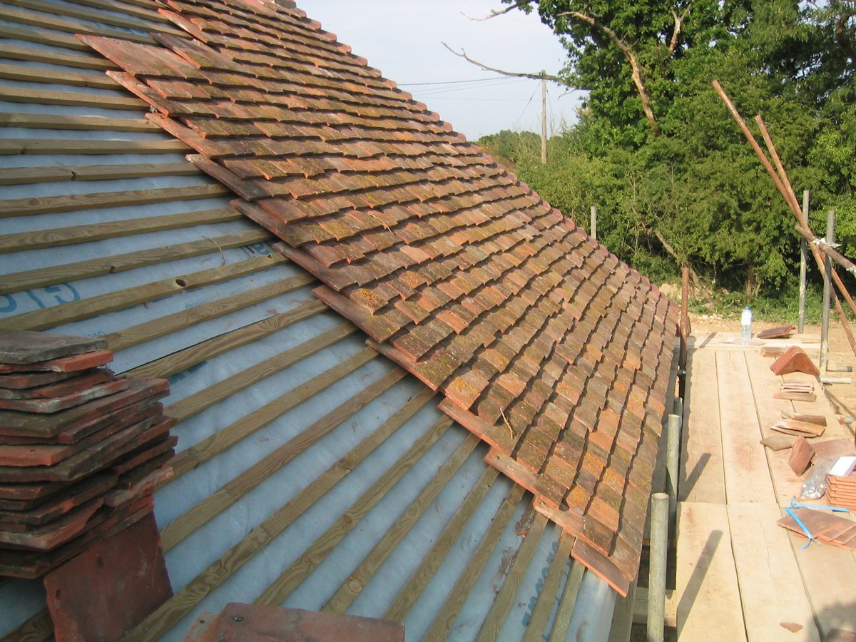 Reclaimed clay tile laying on barn roof — West Sussex heritage barn conversion