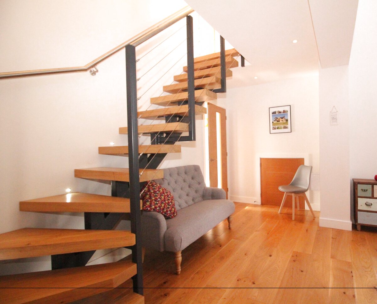 Contemporary entrance hall with bespoke spiral staircase — Tyne View House, Northumberland
