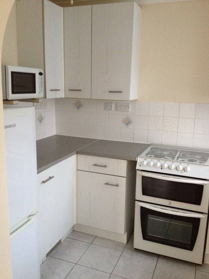Before flood remediation — original dated kitchen, Weyview Court apartment, Guildford