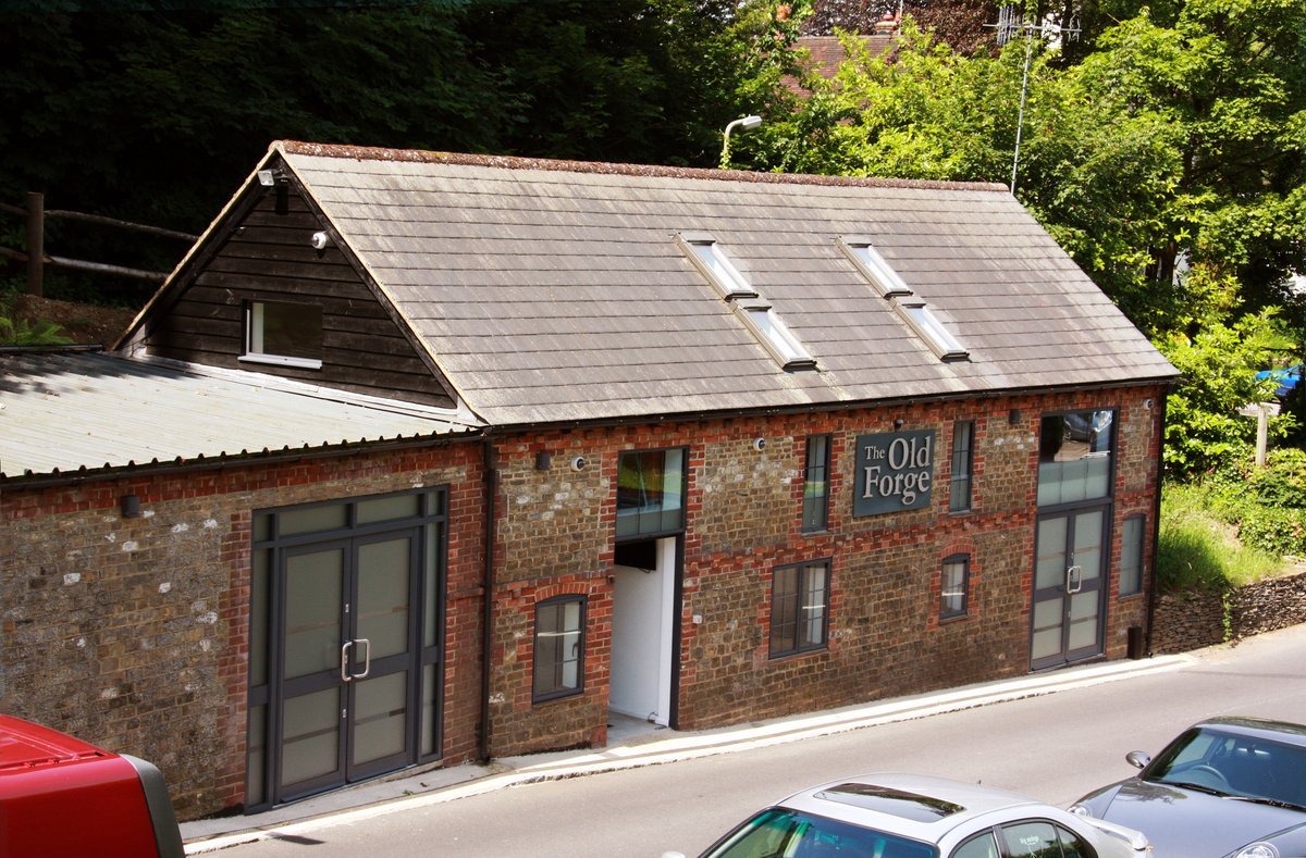 The Old Forge Godalming after commercial conversion — restored brick frontage with new signage and modern fenestration