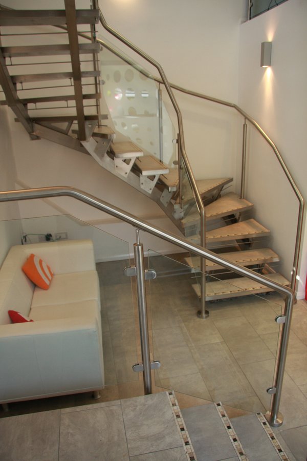 Bespoke stainless steel and glass open-riser staircase — premium commercial fit-out, Godalming — premium commercial fit-out at The Old Forge, Godalming