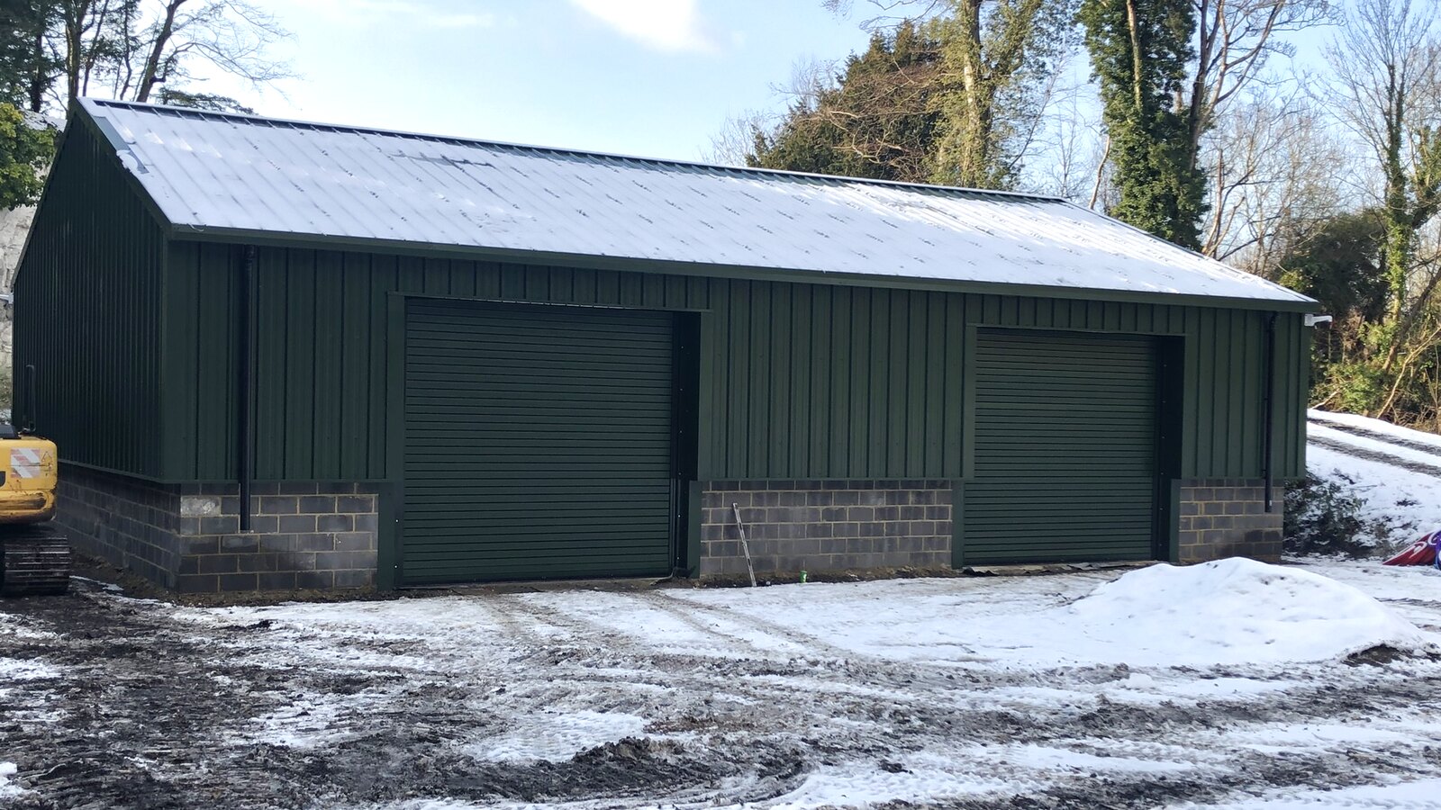 Completed green-clad industrial unit at Quarry Works, Surrey — principal contractor delivered new-build