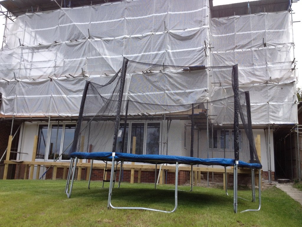 Mid-construction with scaffolding and Monarflex weatherproofing — The Mount, Guildford